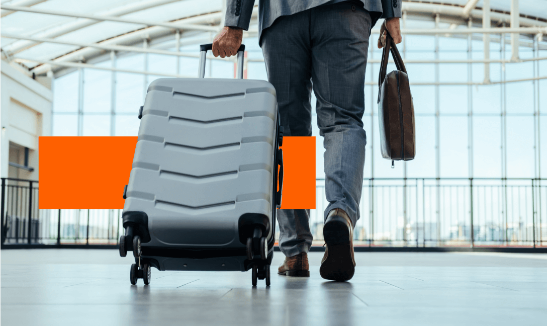 How Financial Institutions Build Loyalty Through Travel Redemptions - person traveling through the airport pulling a rolling suitcase